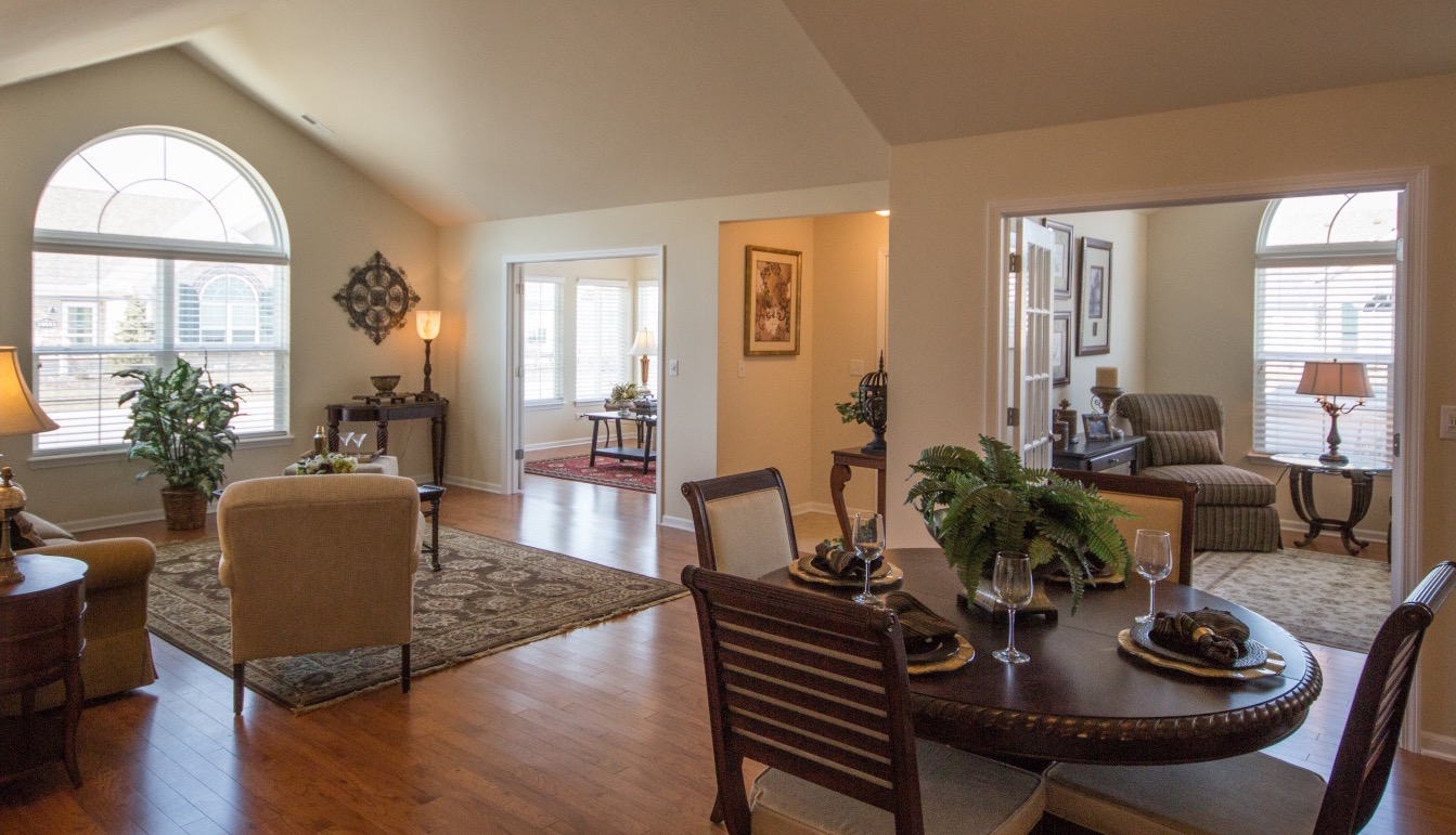 Eye-level view of an open-style living room and breakfast area with an alcove in between an office and bonus room.