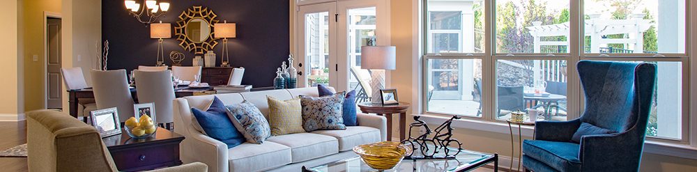 A view of an Epcon home living room in front of a large picture window and double glass doors.