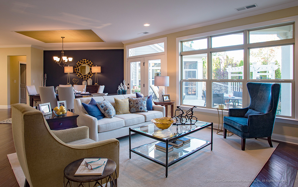 A view of an Epcon home living room in front of a large picture window and double glass doors.