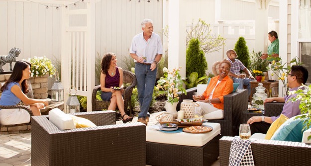 A group of middle-aged and senior adults enjoy a low-key party in the patio area of an Epcon home.